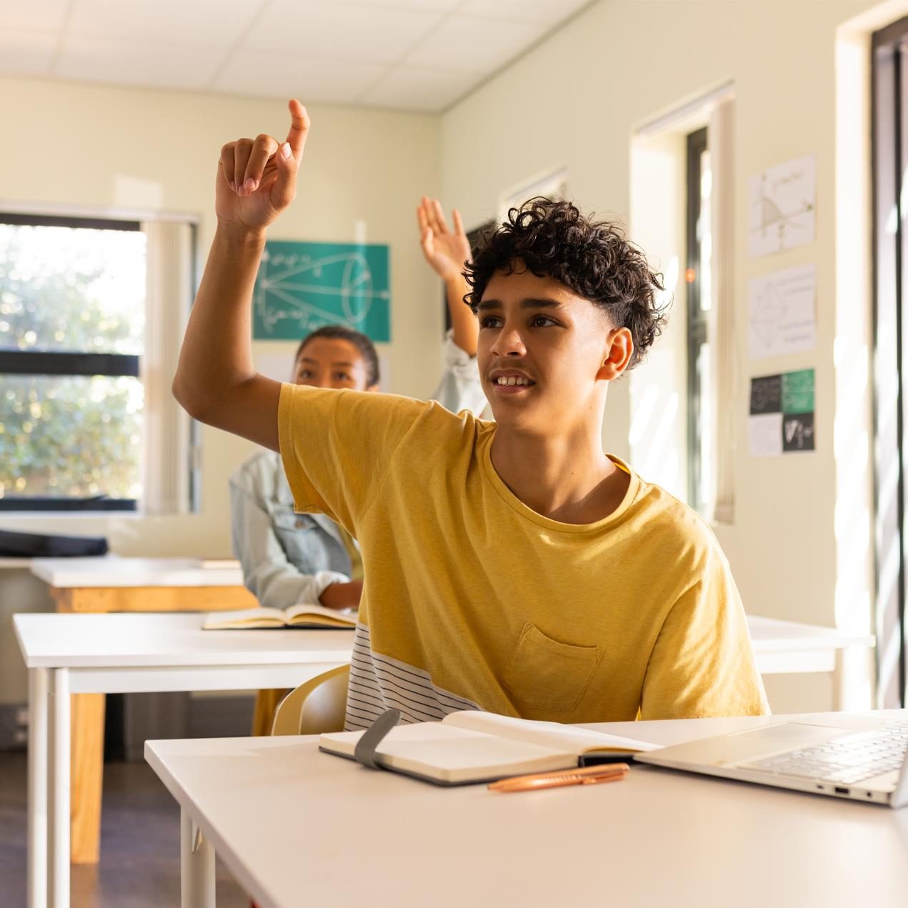 high-school-teenage-boy-raising-hand-while-sitting-desk-with-laptop high-school-teenage-boy-raising-hand-while-sitting-desk-with-laptop